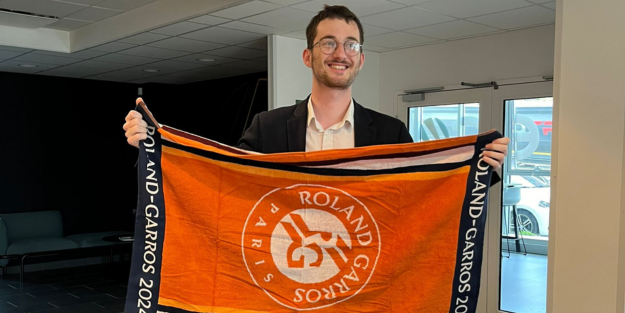 Étudiant souriant tenant une serviette Roland-Garros 2024