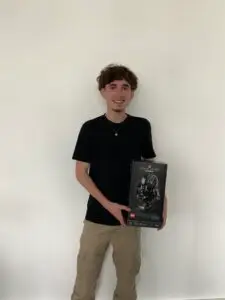 Ethan, jeune étudiant au campus Ecofac le Mans pose avec le casque de dark vador en légo