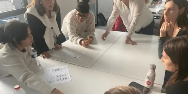 plusieurs étudiants échangent autour d'une table lors d'un projet de groupe