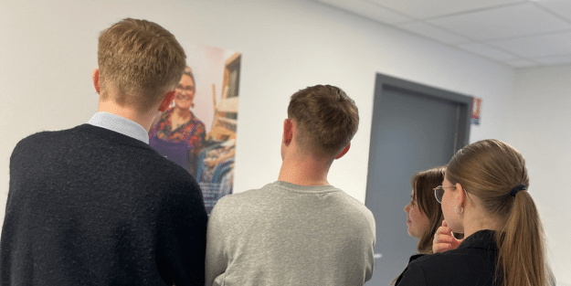 Plusieurs étudiants Ecofac qui regarde une affiche installée dans le cadre de la journée internationale des droits des Femmes