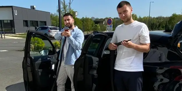 Deux étudiants Ecofac Laval qui posent devant une voiture
