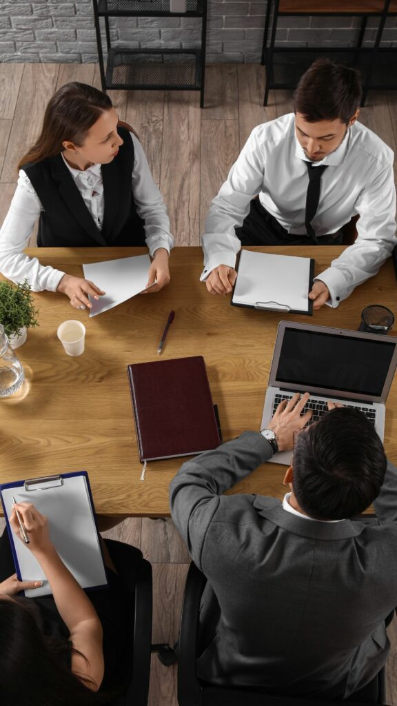 4 personnes travaillant ensemble sur un bureau, pour illustrer le travail collectif