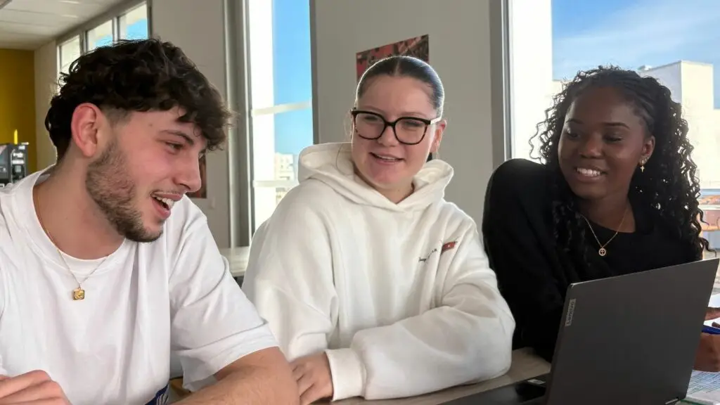 3 étudiants discutent sur le rooftop pendant l'été
